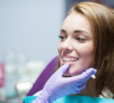 Dentist examining patient's smile after CEREC same day dental crowns