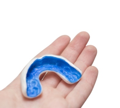 Hand holding a custom nightguard for bruxism