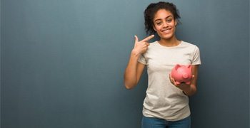 a patient smiling and holding a piggy bank