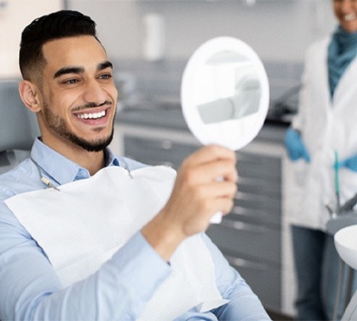 Man looking at his smile in a mirror