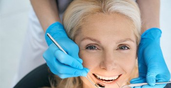 a patient smiling while getting a dental checkup