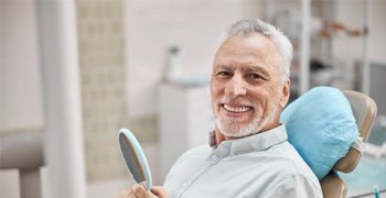 a patient smiling after receiving dental implants