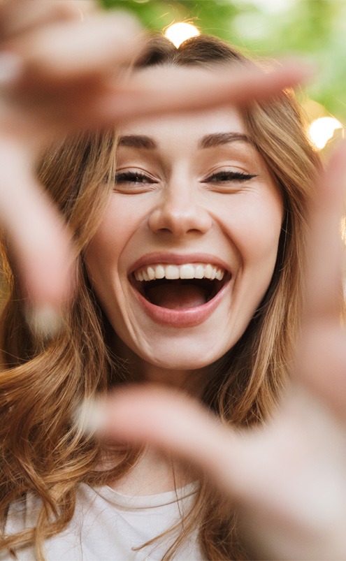 Young smiling woman making a square shape with her fingers