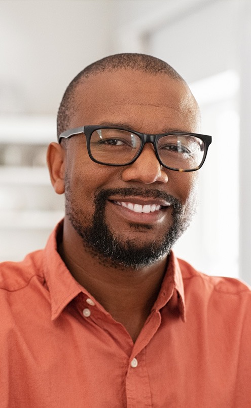 Smiling man in glasses and orange button up shirt