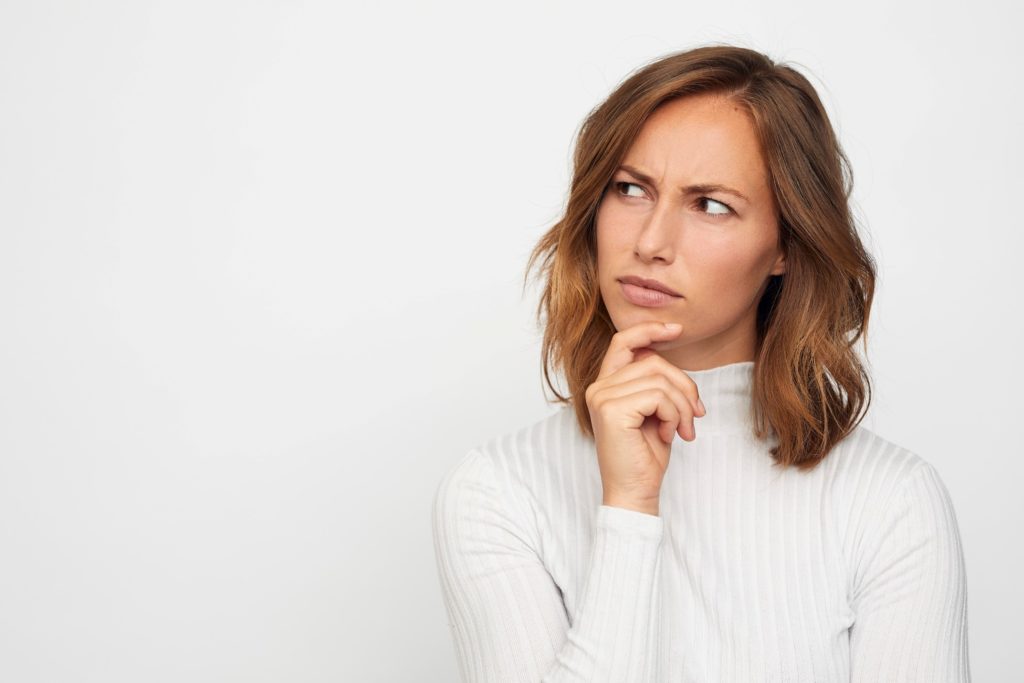 Woman in white, long-sleeve shirt wondering