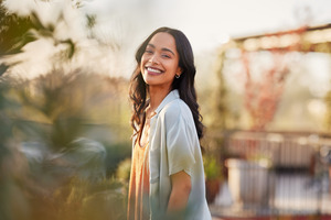 Woman with a beautiful smile walking through garden