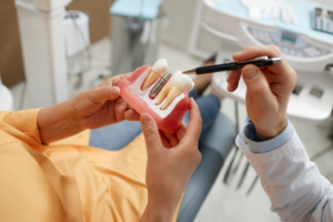 a patient examining a model of dental implants