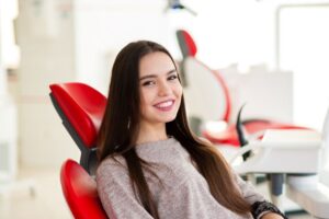 Happy, smiling dental patient in treatment chair 